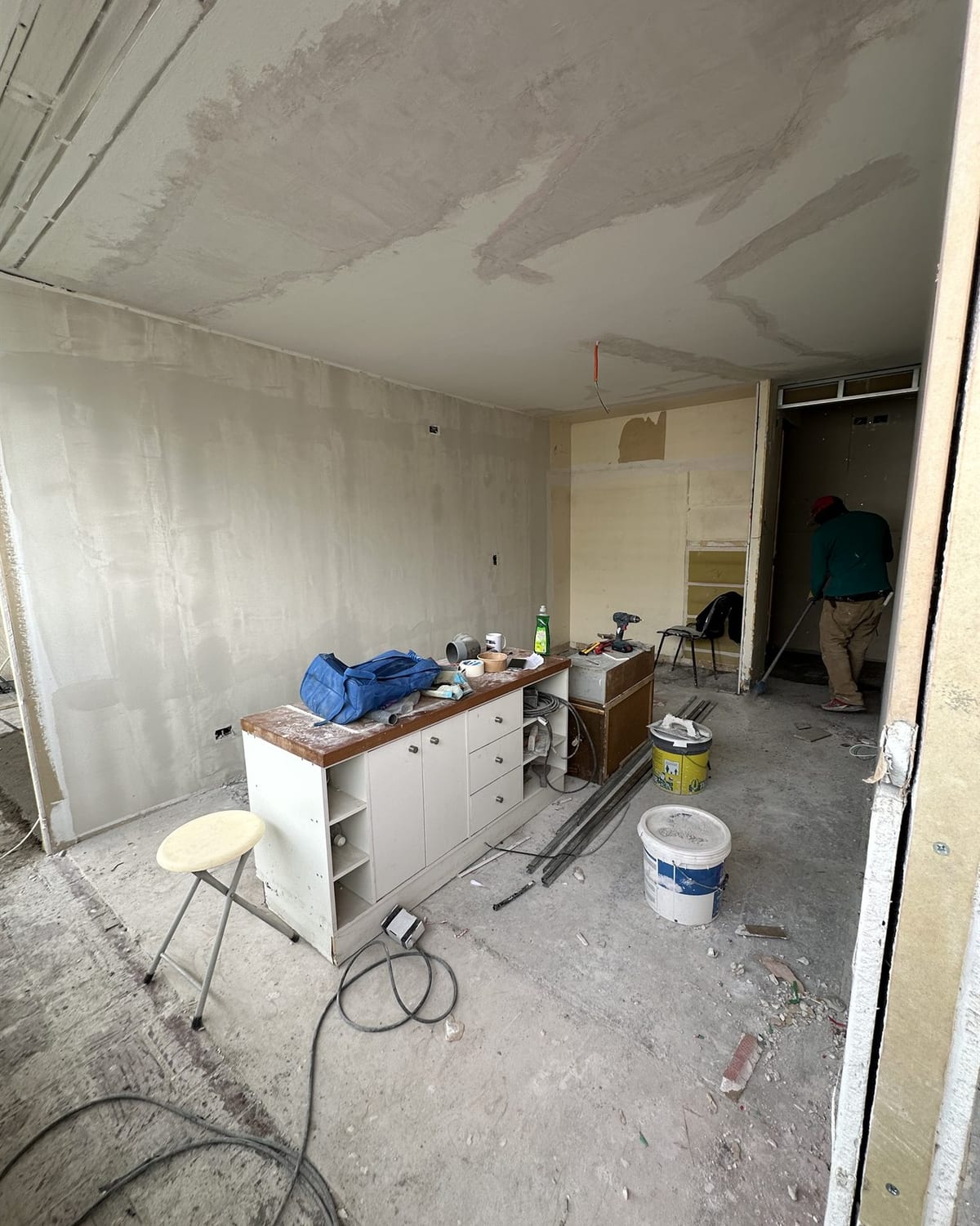 El departamento durante la obra: muebles antiguos desarmados, radier a la vista y muros sin terminar